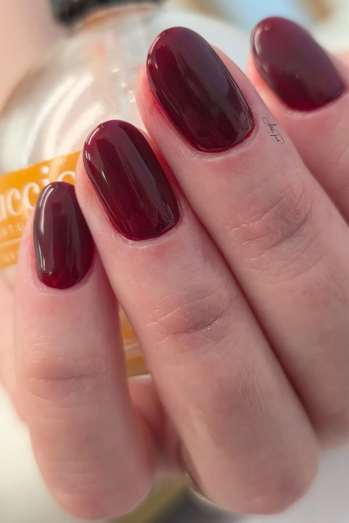 Deep burgundy glossy manicure on short rounded nails