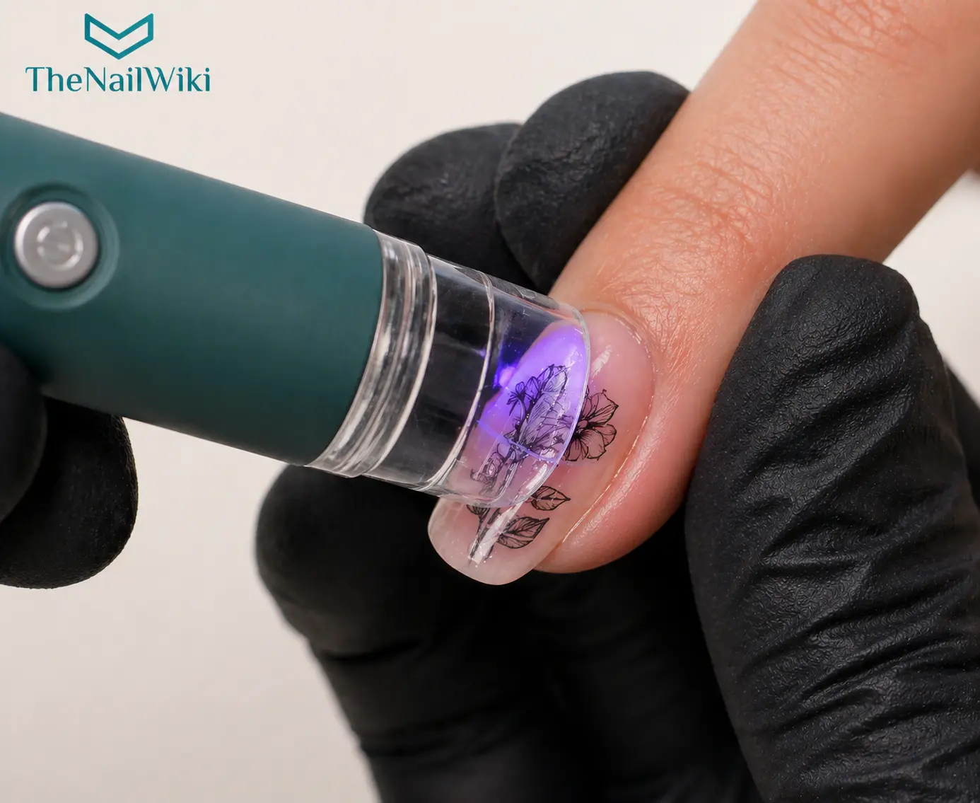 Flash cure lamp with stamper end being used to tack a stamped nail art design onto the nail before a top coat is applied