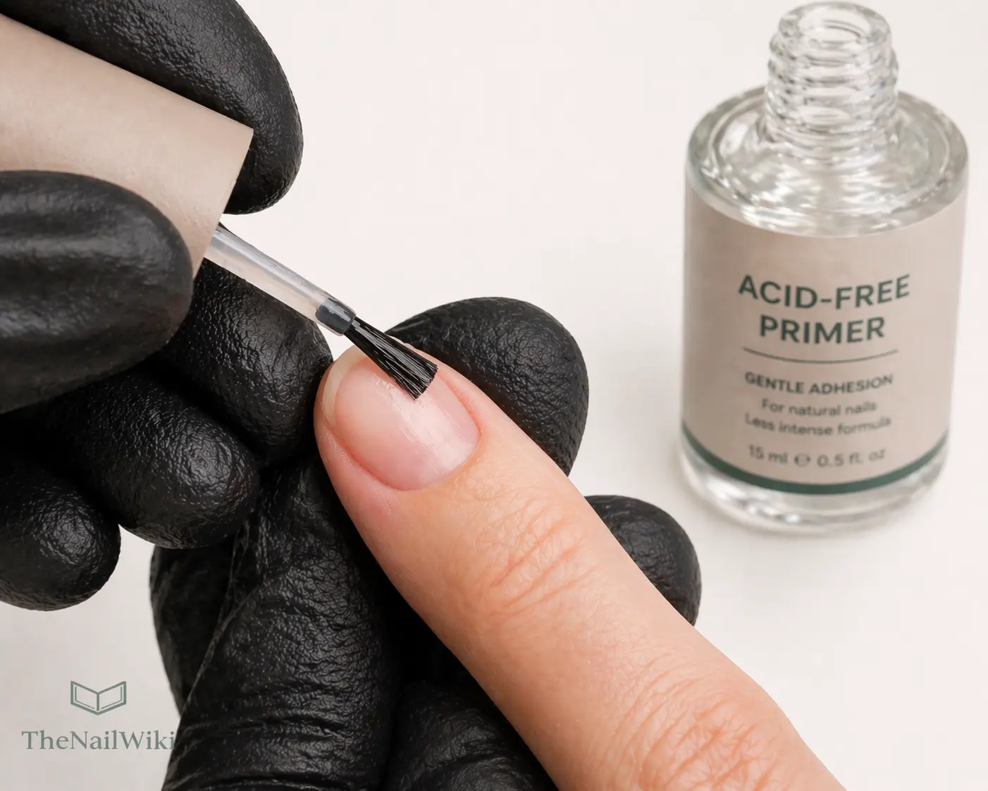 Nail primer being applied to a natural nail with an almost dry brush — thin precise application to the nail plate only, avoiding all surrounding skin