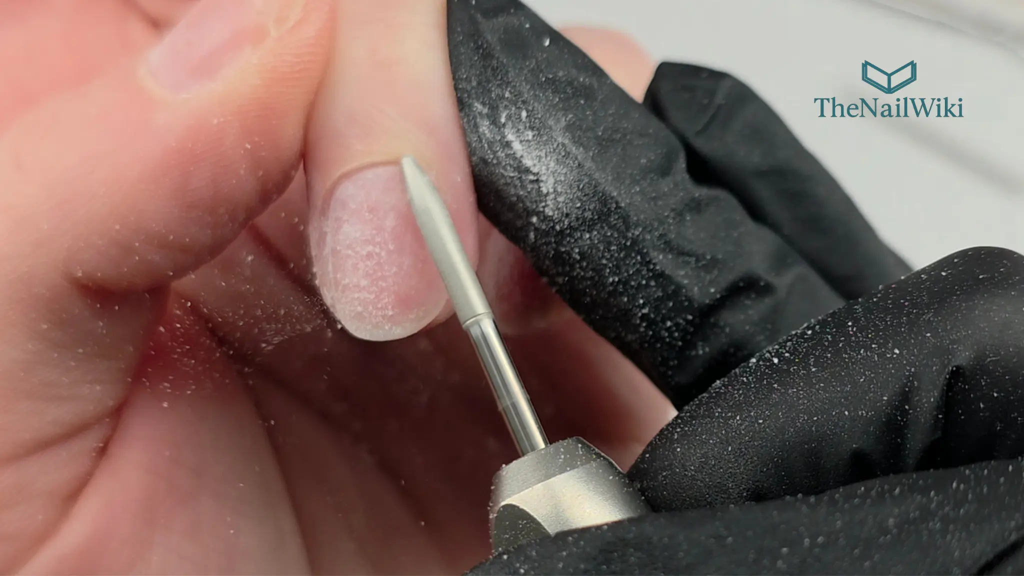 Professional e-file being used on the cuticle zone of a natural nail — removing dead cuticle with a fine diamond bit during nail plate preparation