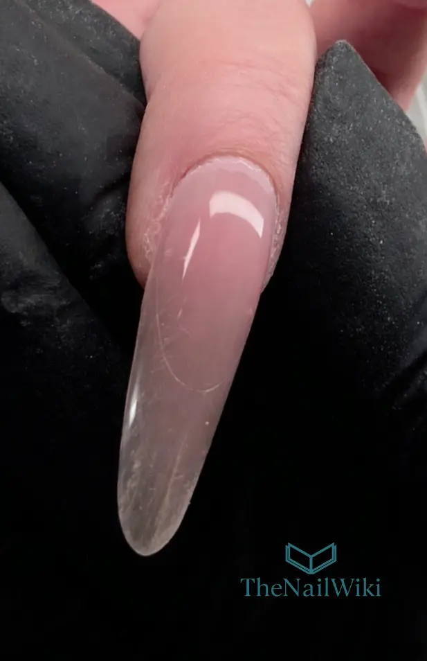 Finished nail enhancement after Sandwich dual form application — clean almond shape in nude polygel with no top coat, showing the natural refined profile after minimal filing